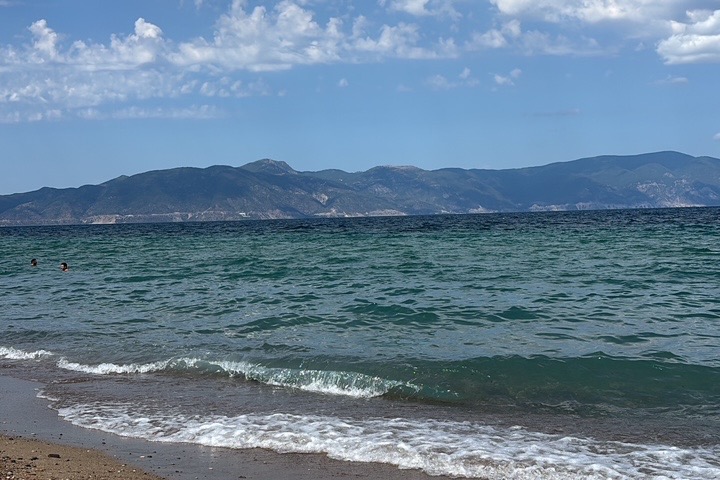 Καθαρή θάλασσα Αρκίτσας με βουνά Εύβοιας στο βάθος
